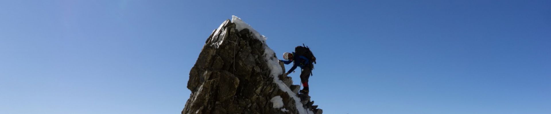 Un grimpeur au sommet pendant un des stages Montagne du bureau des guides