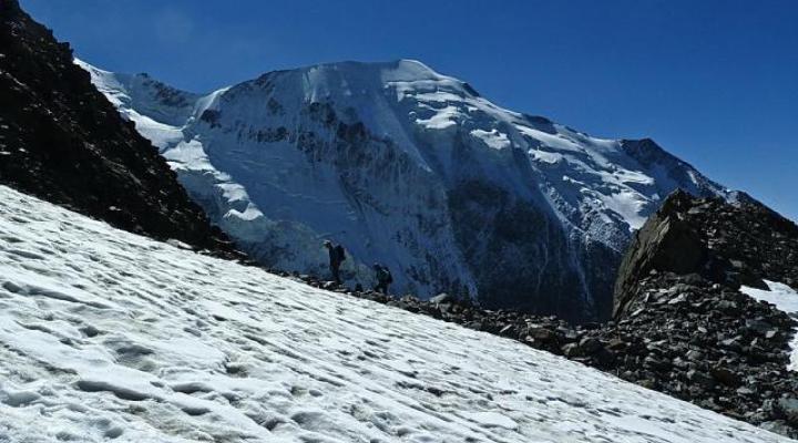 Montée au refuge du Goûter sur fond de face nord de Bionnassay.