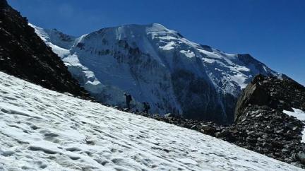 Montée au refuge du Goûter sur fond de face nord de Bionnassay.