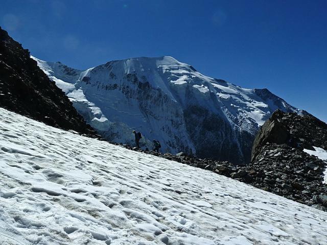 Montée au refuge du Goûter sur fond de face nord de Bionnassay.